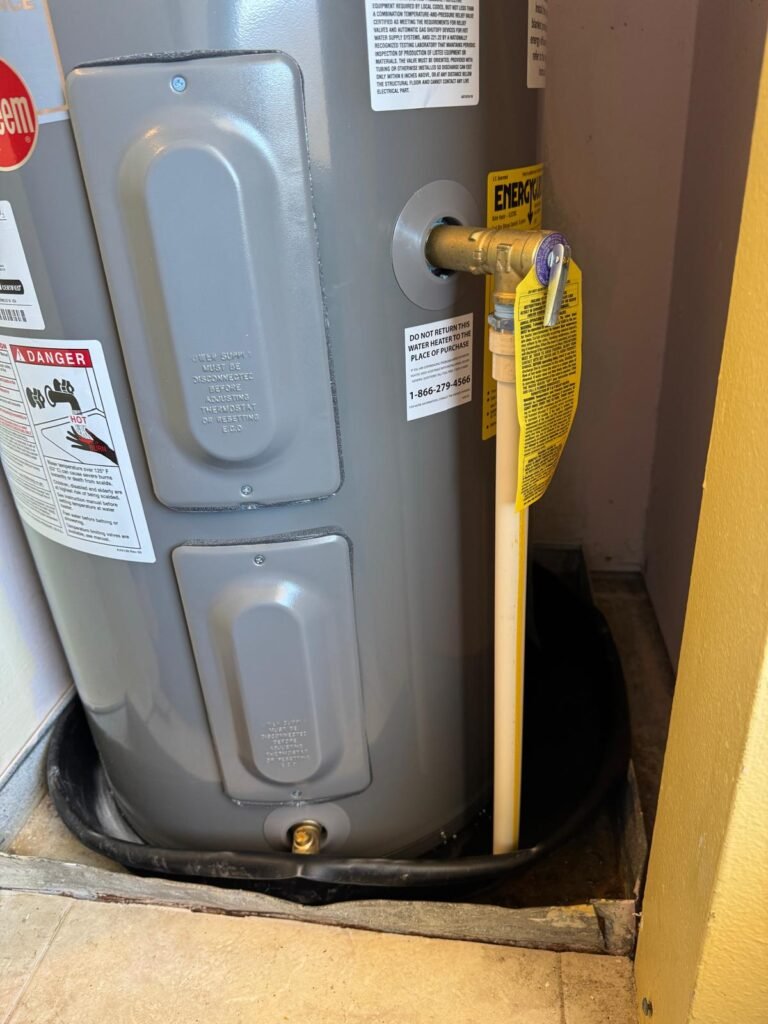 A Rheem tank in a drain pan, with the relief valve discharge line run down the side, in Redington Shores, FL 33708.