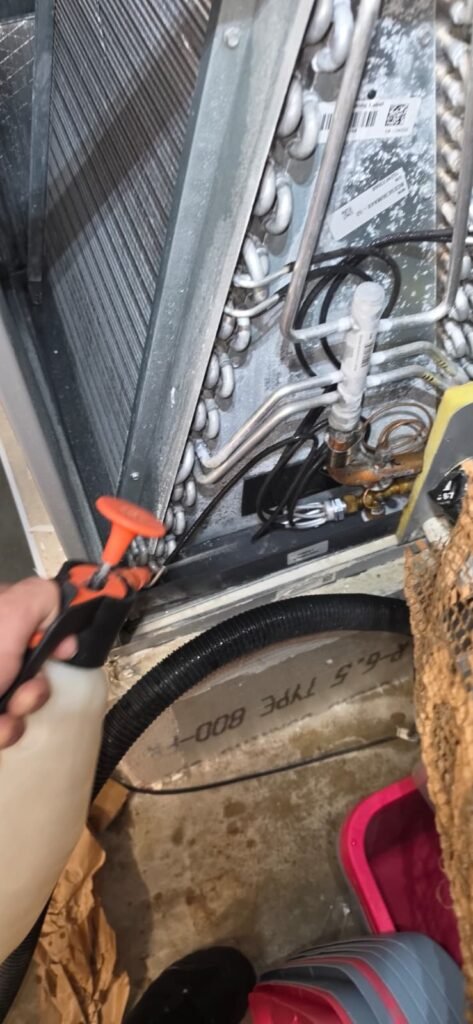Spraying coil cleaner on an AC coil during a maintenance visit in Tampa, FL 33606.