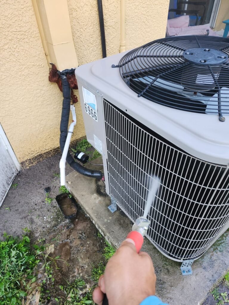 Home Therapist technician rinsing an AC condenser coil during an $89 tune-up in Riverview, FL