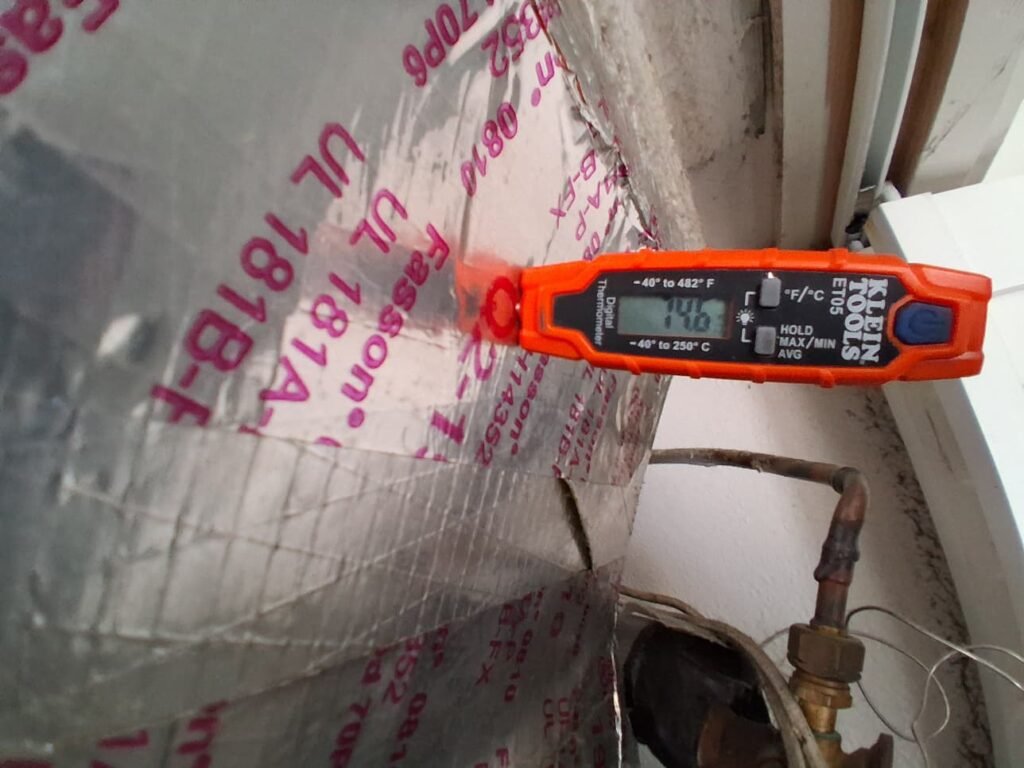Checking air temperature at the duct during an inspection in St. Petersburg, FL 33701.