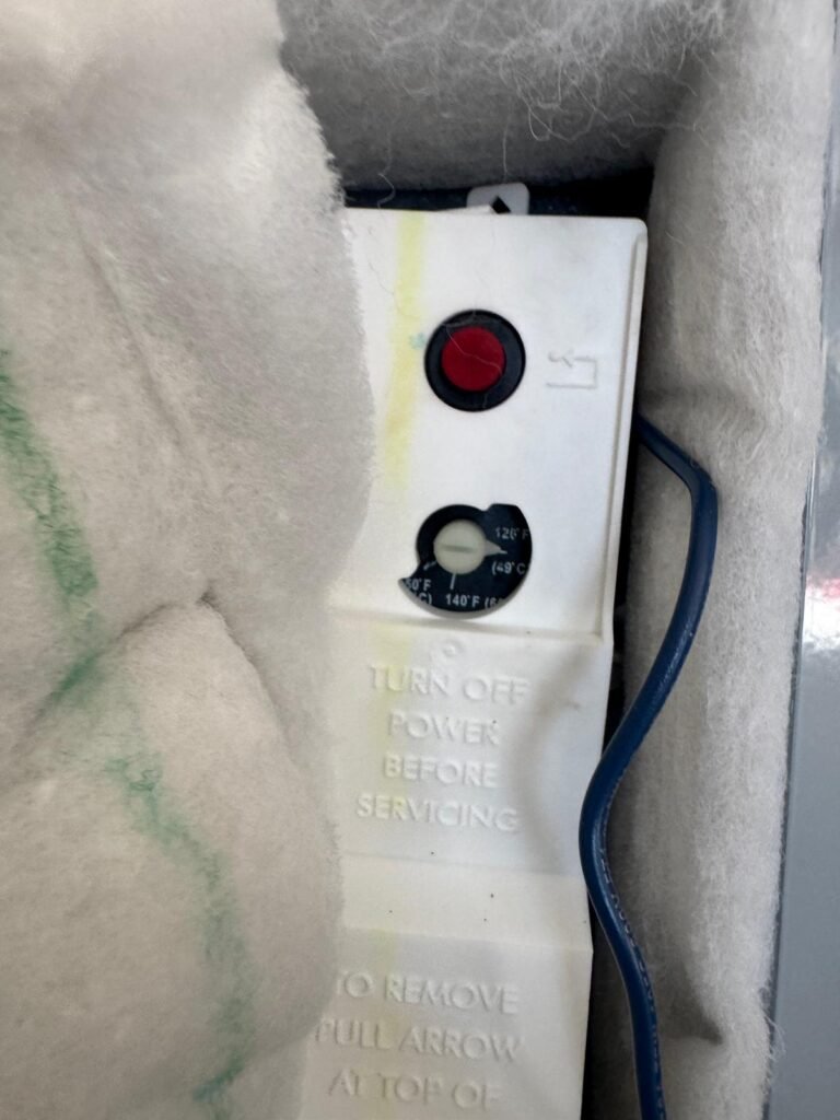 The thermostat behind the access panel of an electric water heater in Riverview, FL 33579.