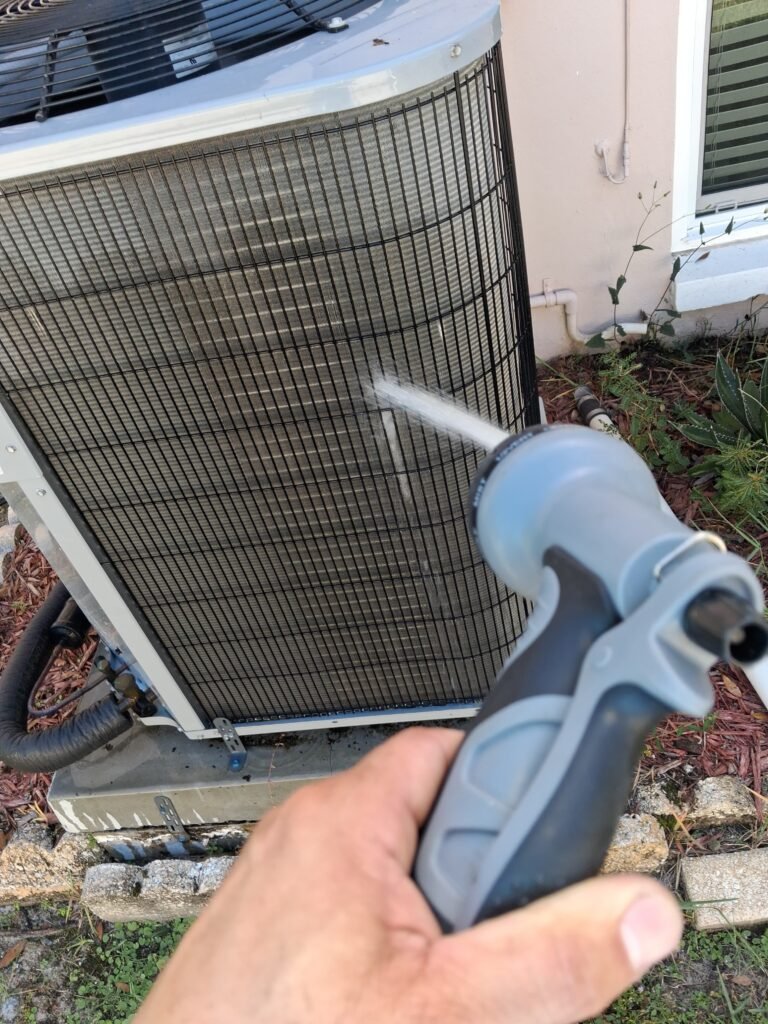Technician cleaning AC unit during tune-up in Clearwater, FL 33762