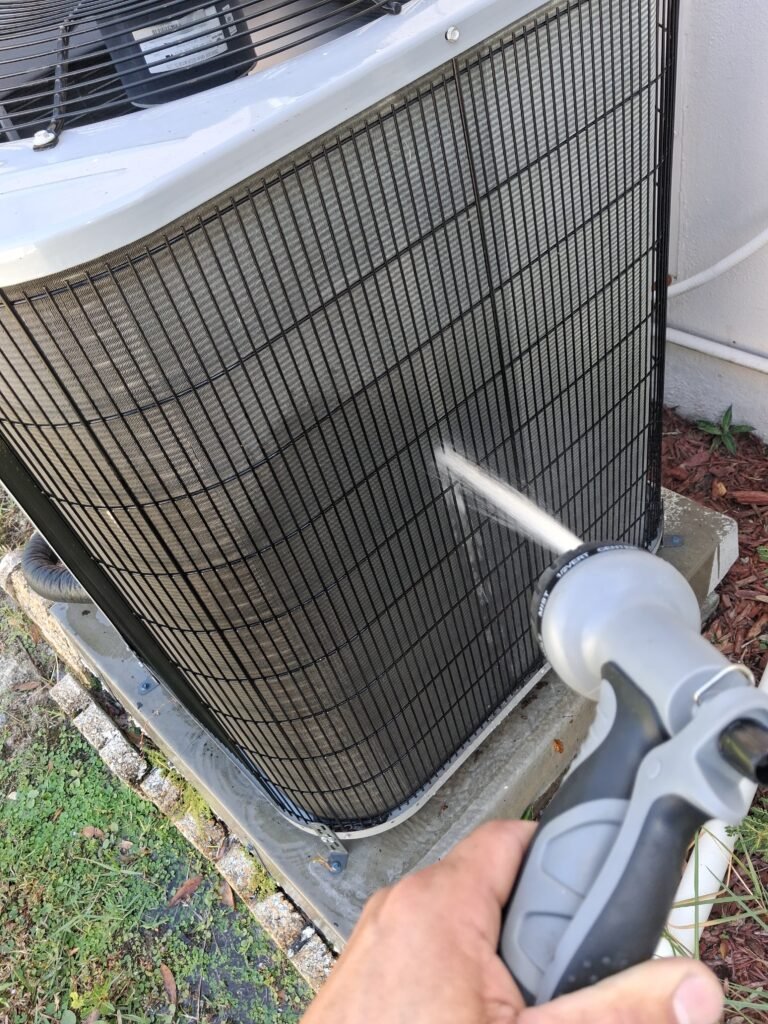 Technician cleaning AC unit during tune-up in Clearwater, FL 33762