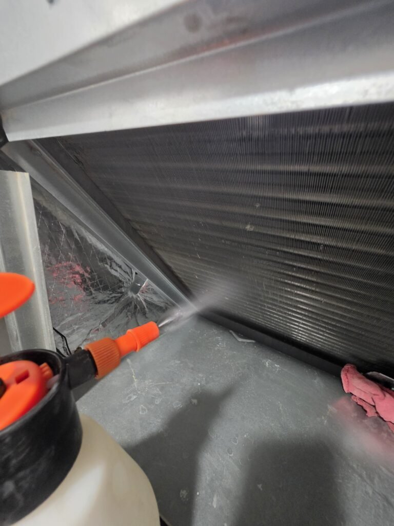 Spraying cleaner on an air handler coil during a tune-up in St. Petersburg, FL 33712.