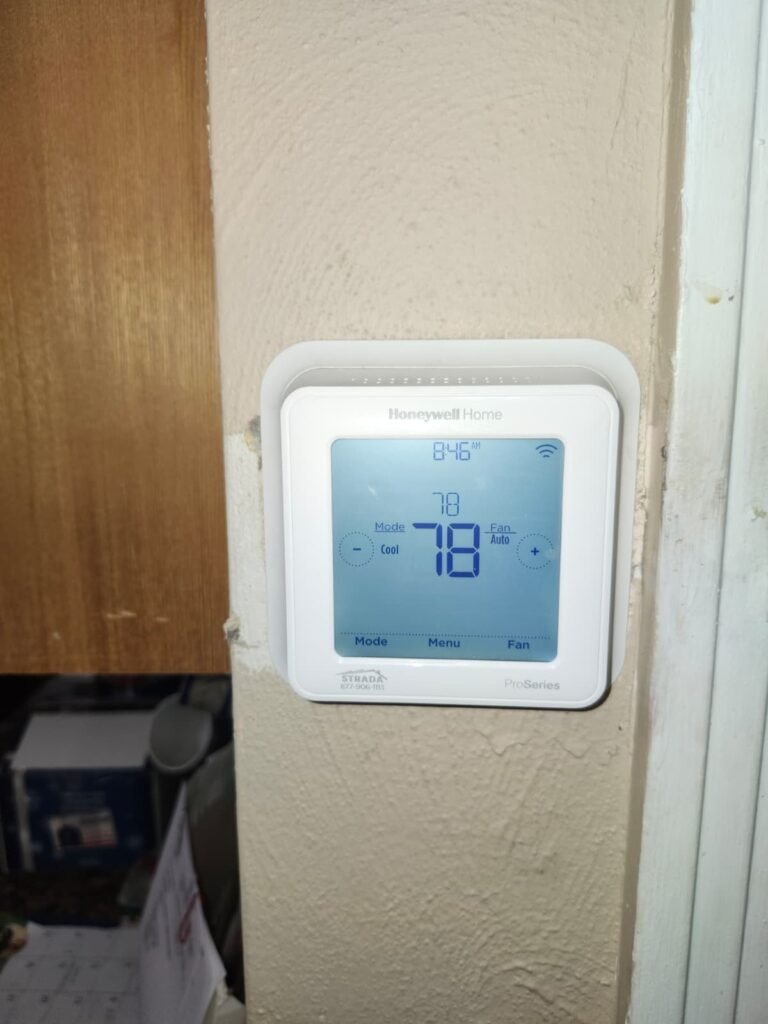 A programmable thermostat installed on a wall in Tampa, FL 33610.