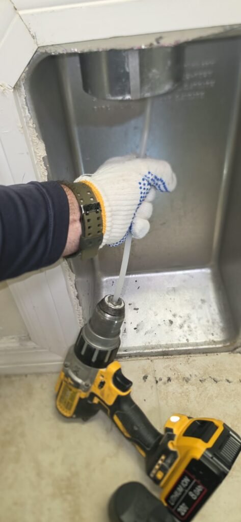Cleaning a dryer duct with a rotary brush on a drill in Tampa, FL 33647.