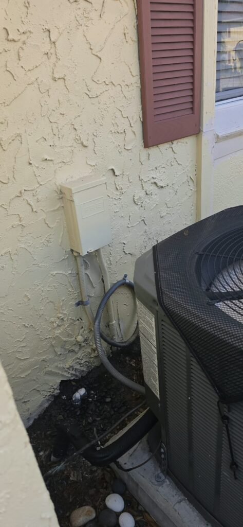 Exterior AC unit next to house wall after service in Tampa, FL 33615