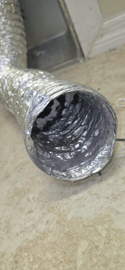 Lint packed inside a flexible dryer duct in Tampa, FL 33647.