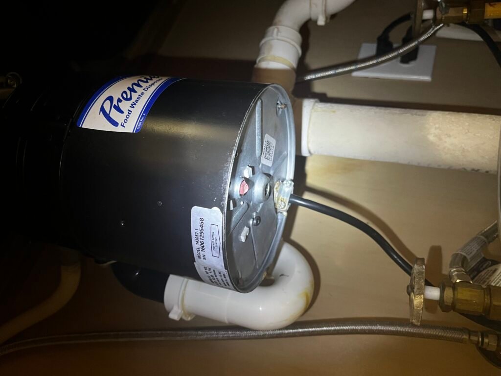 A garbage disposal mounted under a kitchen sink in Lithia, FL 33547.
