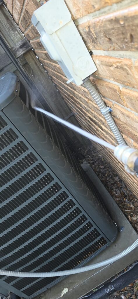 HVAC Unit Cleaning Near Wall, Tampa, FL 33612 HVAC unit cleaning with water spray near wall in Tampa, FL 33612
