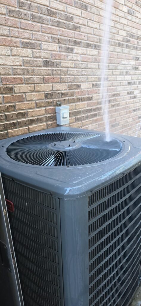 HVAC Unit Water Cleaning in Tampa, FL 33612 Spraying water on HVAC unit during maintenance in Tampa, FL 33612