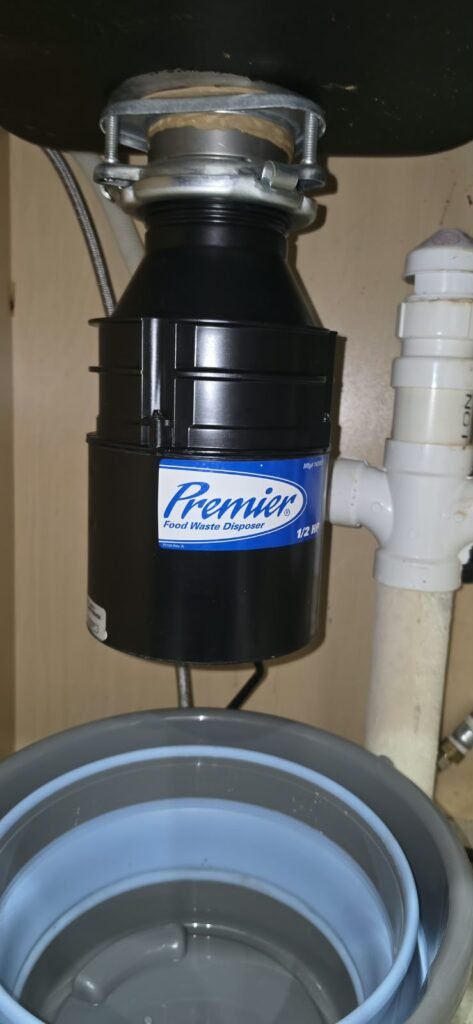 A new garbage disposal installed under a kitchen sink in Lithia, FL 33547.