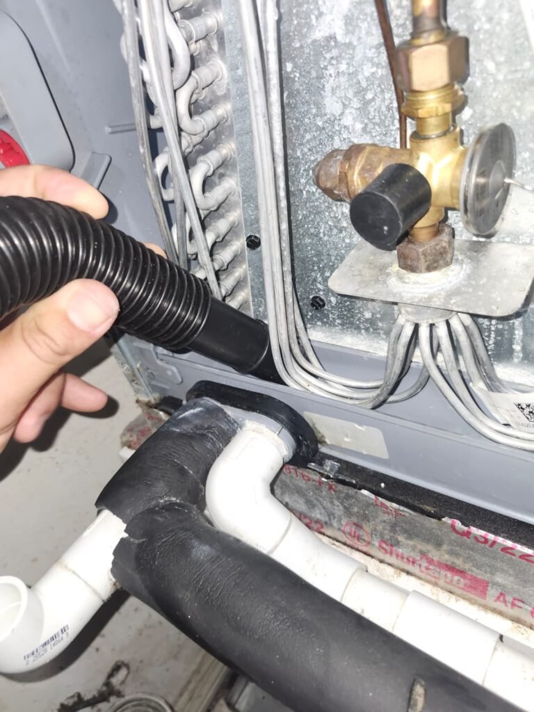 Vacuum cleaning HVAC component during service in Clearwater, FL 33762