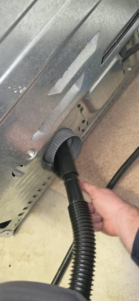 Vacuuming lint from the exhaust port on the back of a dryer in Tampa, FL 33647.