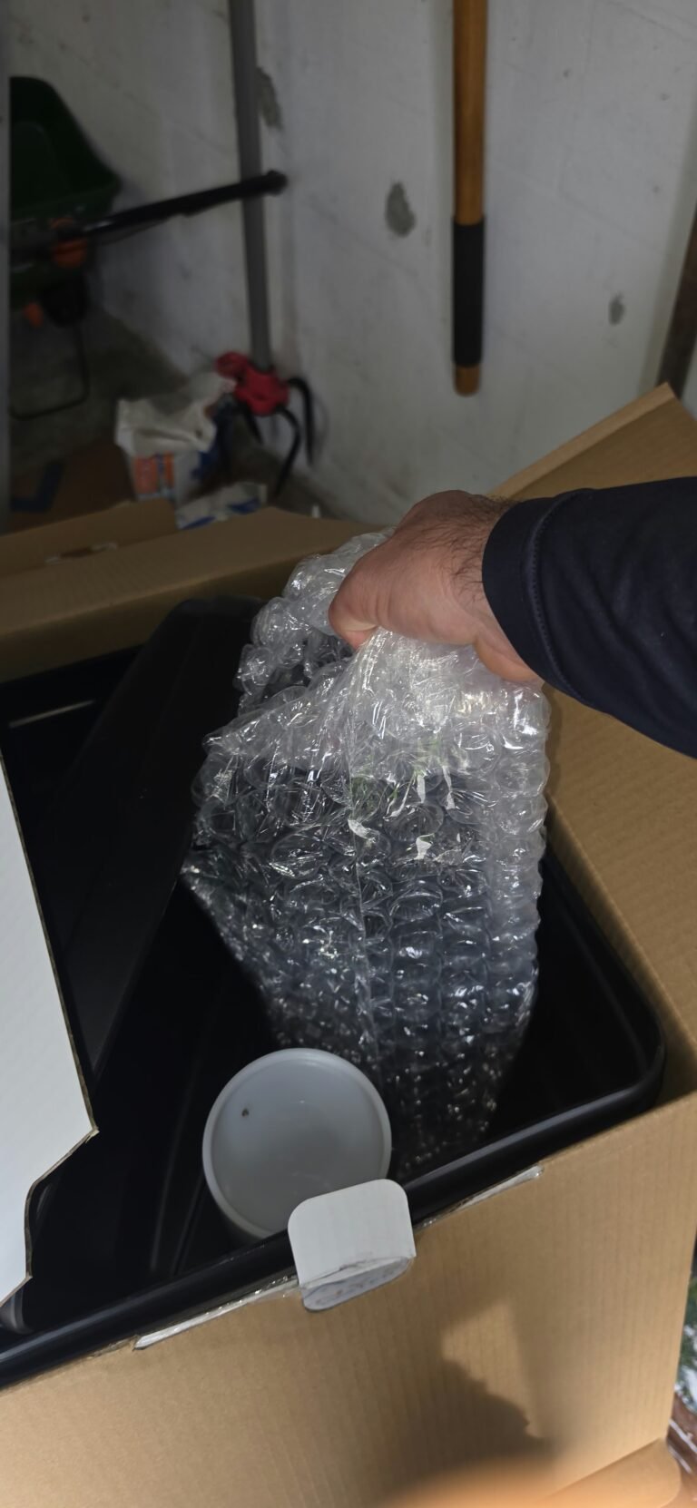 Hand holding bubble-wrapped water softener parts in Lutz, FL 33549