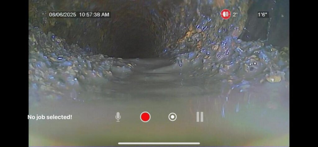 a camera inspection of a pipe showing buildup and blockage in a drainage system indicating potential plumbing issues