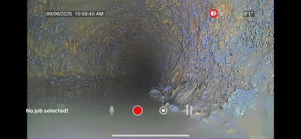 camera inspection of a plumbing pipe showing darkness and sediment buildup indicating potential blockages or issues within the system