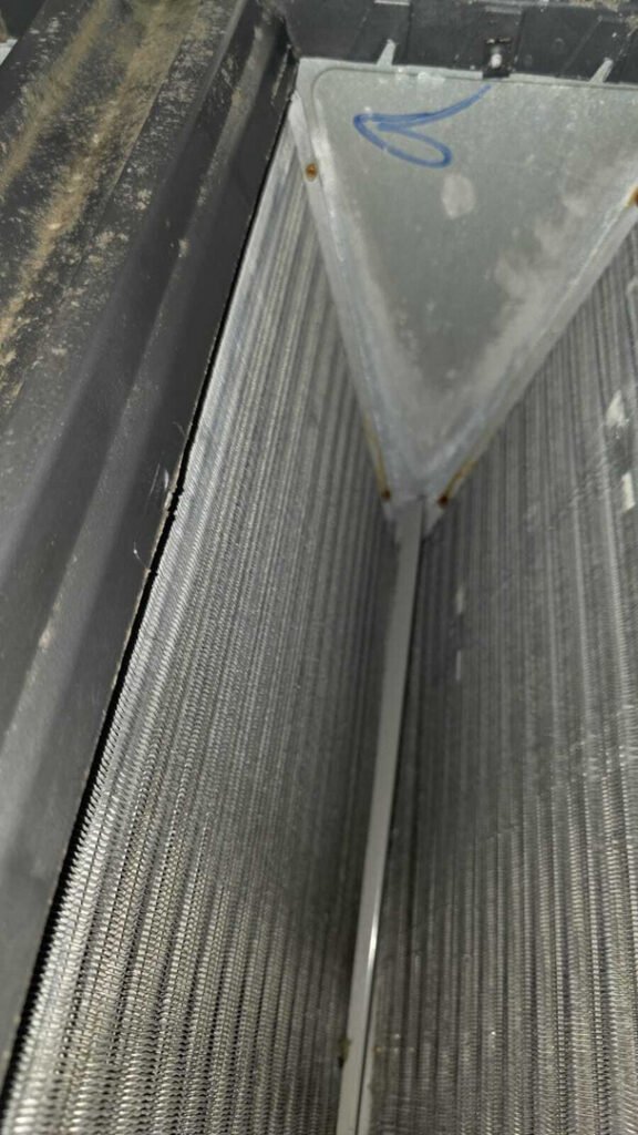 dirty air conditioning coils being inspected or cleaned for better efficiency and performance