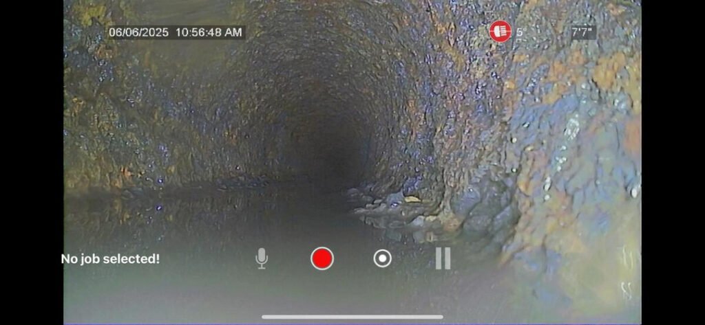 drain inspection using a camera in a dark underground pipe showing buildup and potential blockages