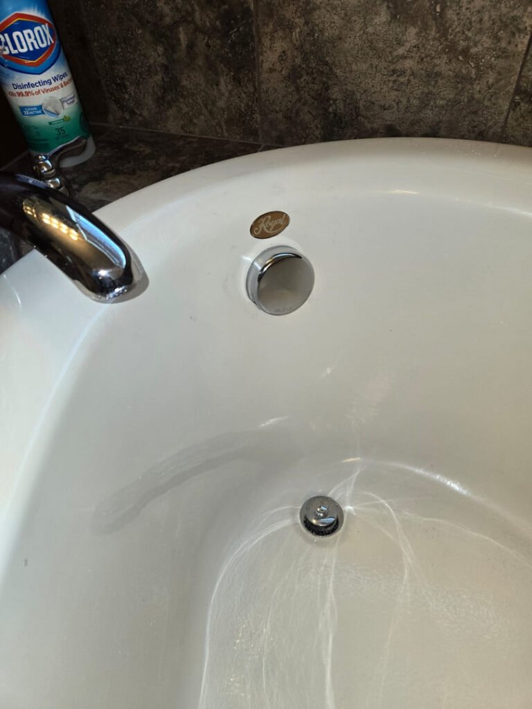 From one of our recent jobs: faucet and drain of a bathtub showing a polished chrome finish with clean white porcelain surface.