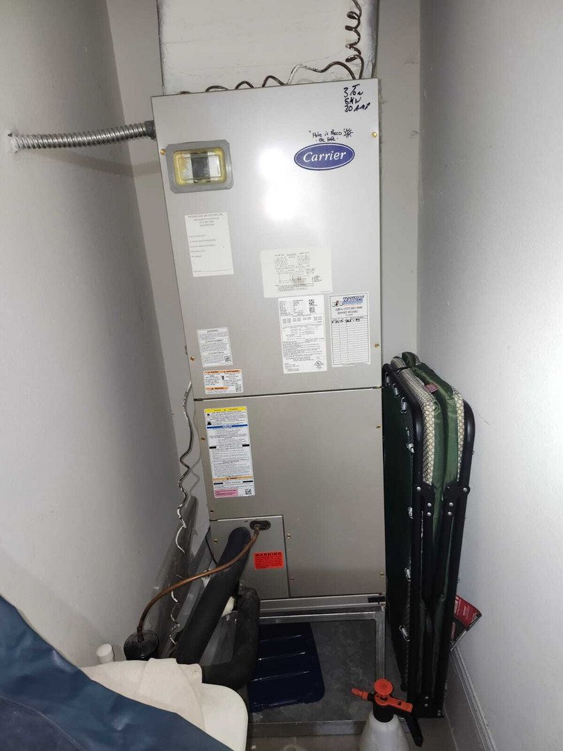 Furnace Installation With A Carrier Unit And Surrounding Ventilation Pipes In A Confined Utility Space