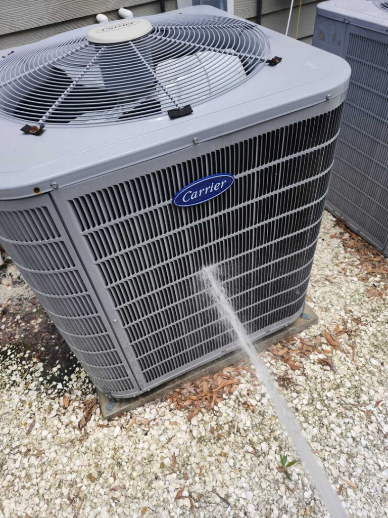 home therapist cooling heating and plumbing cleaning a carrier air conditioning unit with water to remove dirt and debris