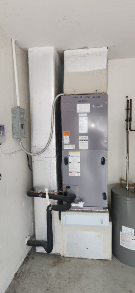home therapist cooling heating and plumbing installing or servicing an air conditioning unit in a residential garage setting