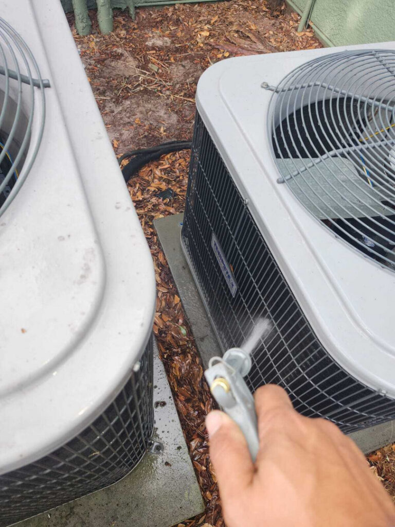 home therapist cooling heating and plumbing performing maintenance on air conditioning units using a cleaning spray nozzle