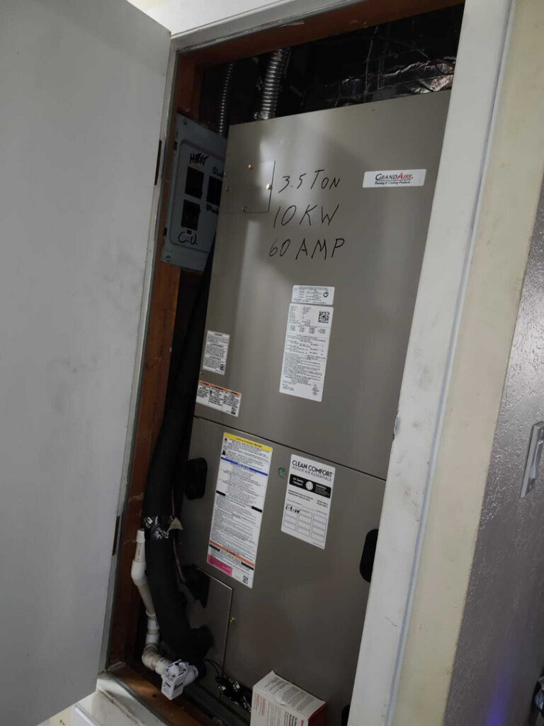 home therapist cooling heating and plumbing servicing a gray air conditioning unit with various electrical and mechanical components visible