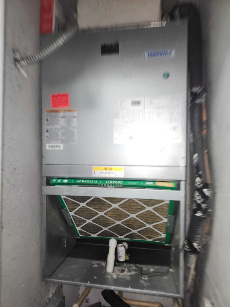 home therapist cooling heating and plumbing servicing an air conditioning unit with a visible air filter and pipes