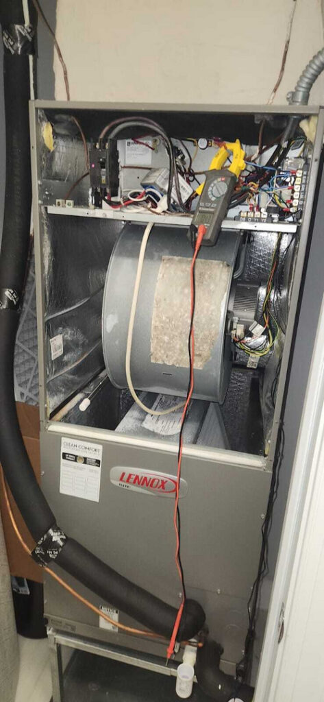 home therapist cooling heating and plumbing servicing an hvac unit with measurement tools visible and parts exposed for inspection