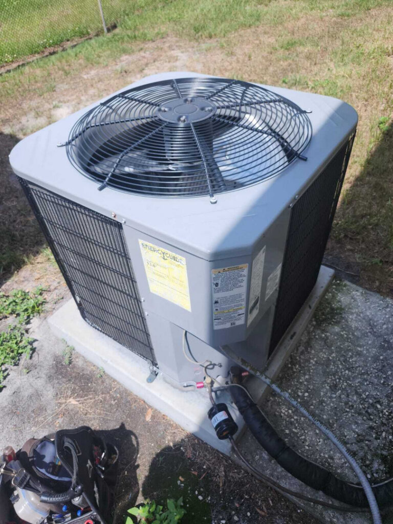 home therapist cooling heating and plumbing servicing an outdoor air conditioning unit with tools laid out nearby