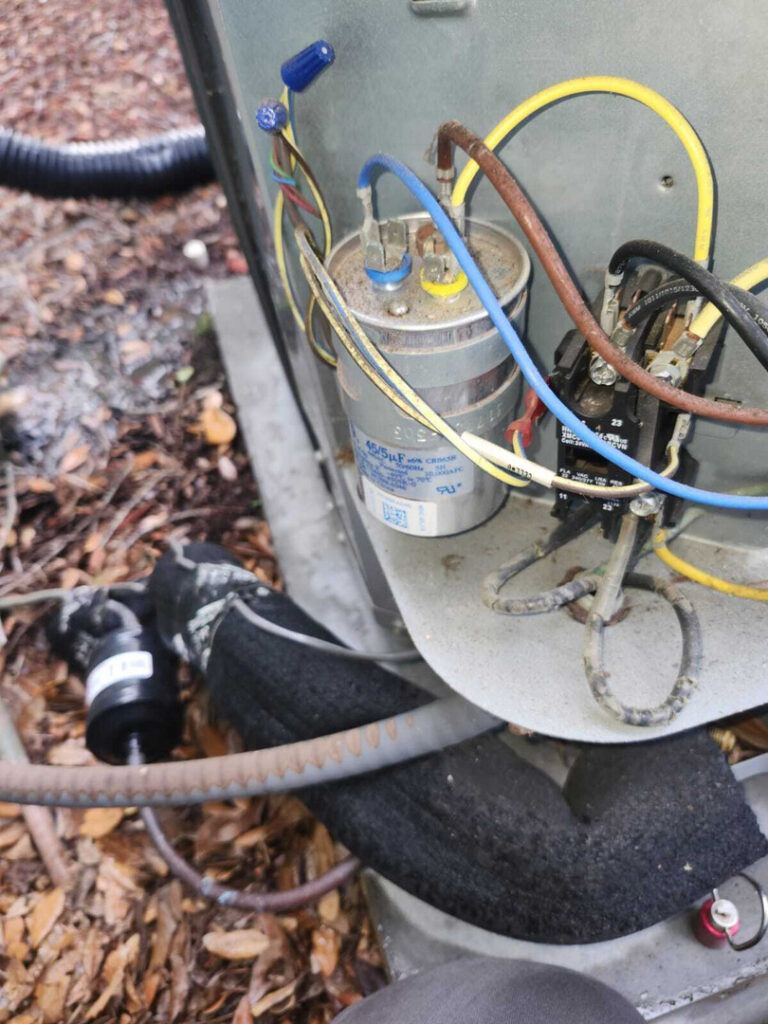 home therapist cooling heating and plumbing servicing an outdoor air conditioning unit with visible electrical components and insulation
