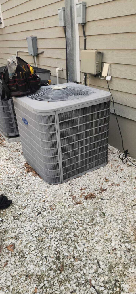 home therapist cooling heating and plumbing servicing outdoor air conditioning units with tools and equipment nearby on gravel surface