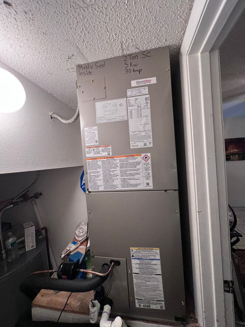 Installation Of A Heating And Cooling Unit With Labels And Wiring Visible In A Residential Setting