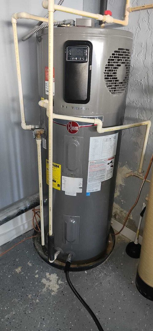 plumber servicing a hot water heater with visible pipes and controls in a residential setting