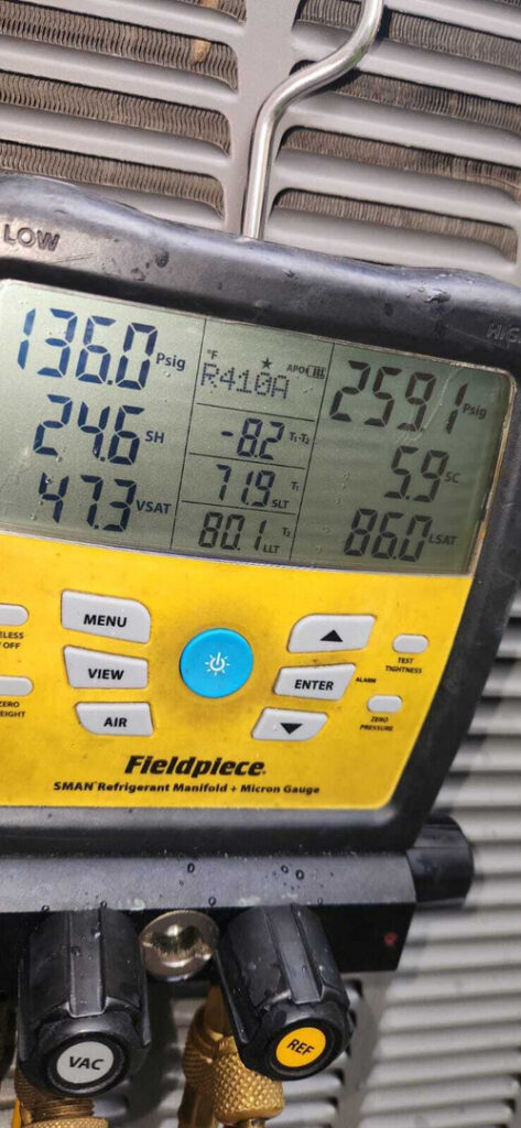 refrigerant gauge with readings for pressures and temperatures indicating service on an air conditioning unit