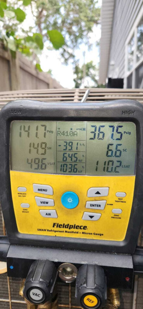 refrigerant pressure measurements being taken using a fieldpiece manifold gauge on an air conditioning unit