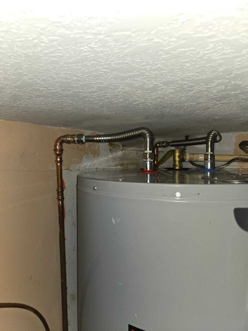service involves installing or maintaining a water heater with copper and flexible piping connections visible in the photo