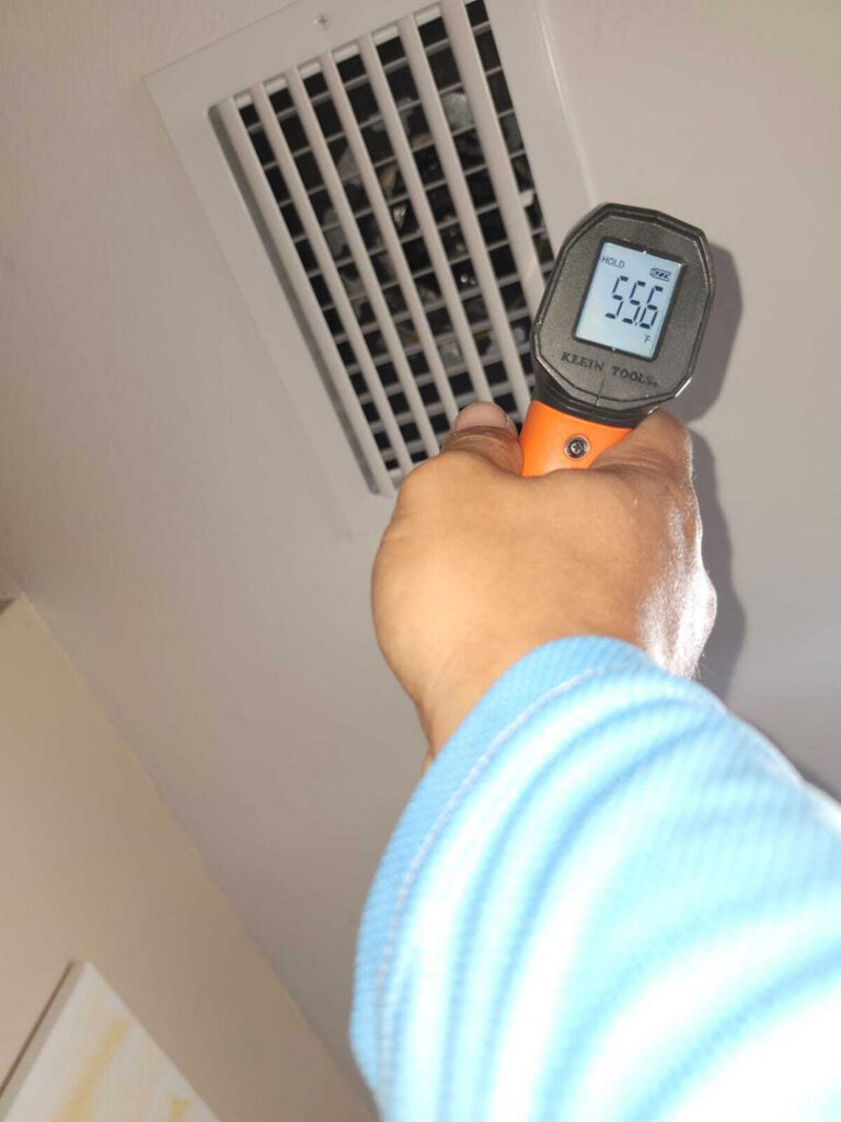 taking the temperature reading of air from a vent using an infrared thermometer