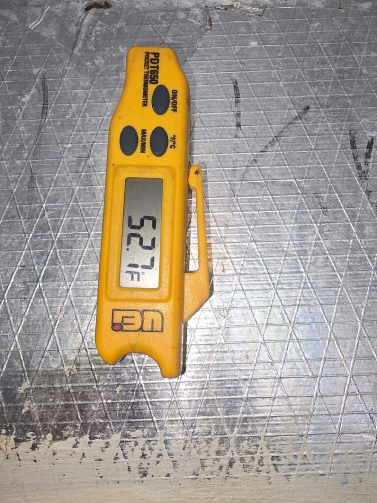 From one of our recent jobs: temperature measurement using a digital thermometer displaying fifty two point seven degrees on a metallic surface.