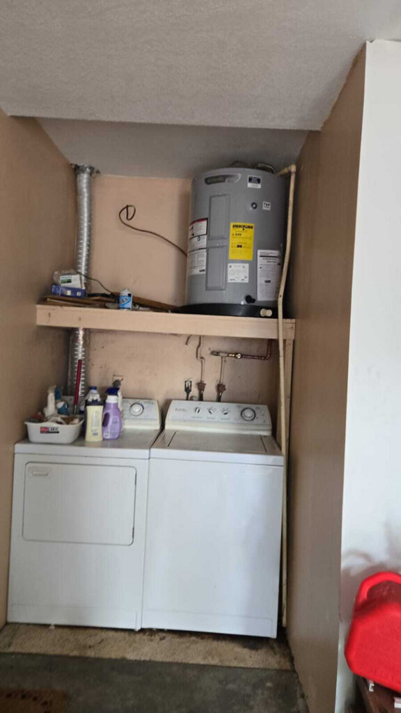 water heater installation and maintenance alongside washer and dryer in laundry area with plumbing connections visible
