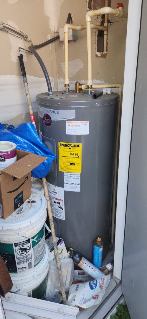 water heater installation with various tools and materials nearby cluttered storage area visible