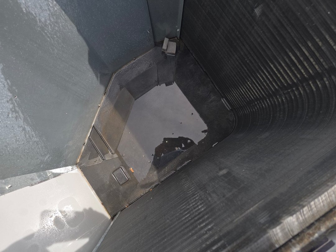 water pooling in a dark container with smooth surfaces possibly related to plumbing or cooling system maintenance