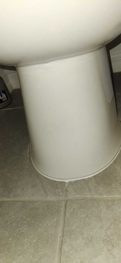 white toilet base on tiled floor possibly indicating plumbing maintenance or inspection taking place nearby