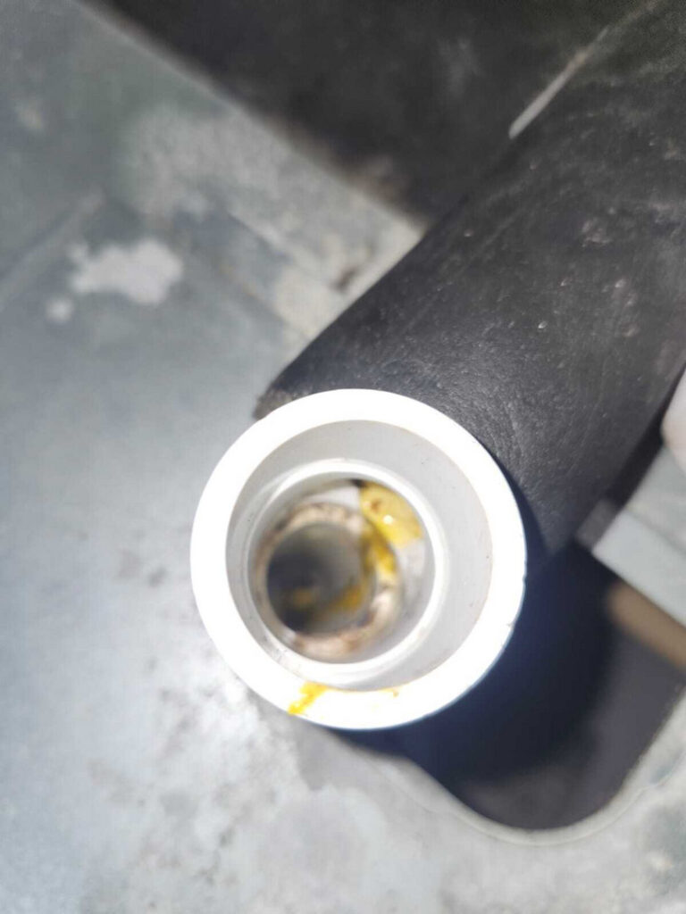 yellow liquid is present inside a pipe or fitting suggesting possible leakage or residue from a cooling or heating system