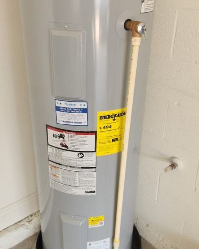 home therapist cooling heating and plumbing installing a new gray water heater with visible pipes and safety labels