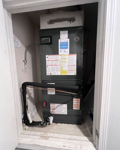 heating system installation with visible pipes and connections in a residential closet space